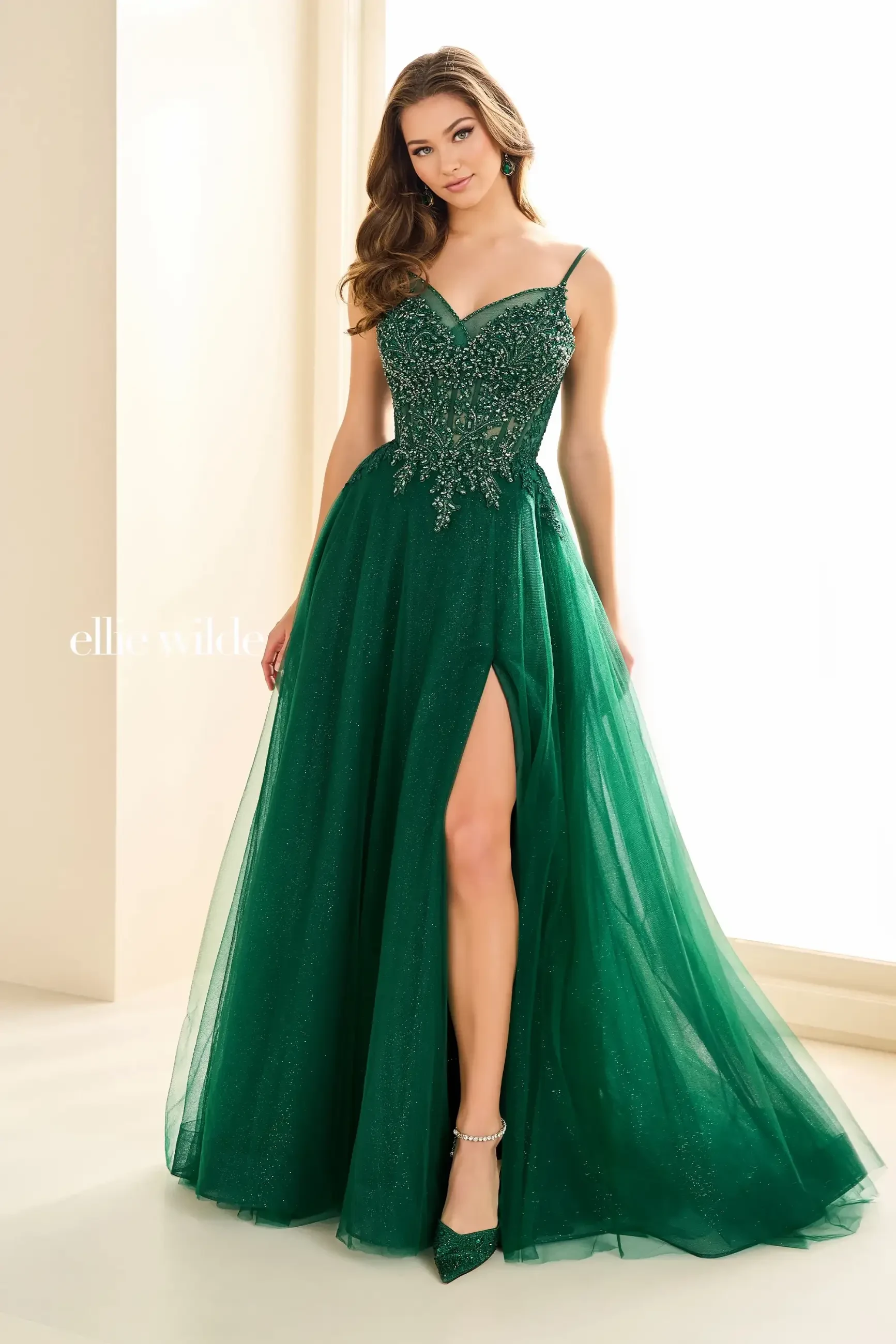 model is wearing a sleeveless a-line emerald green evening gown