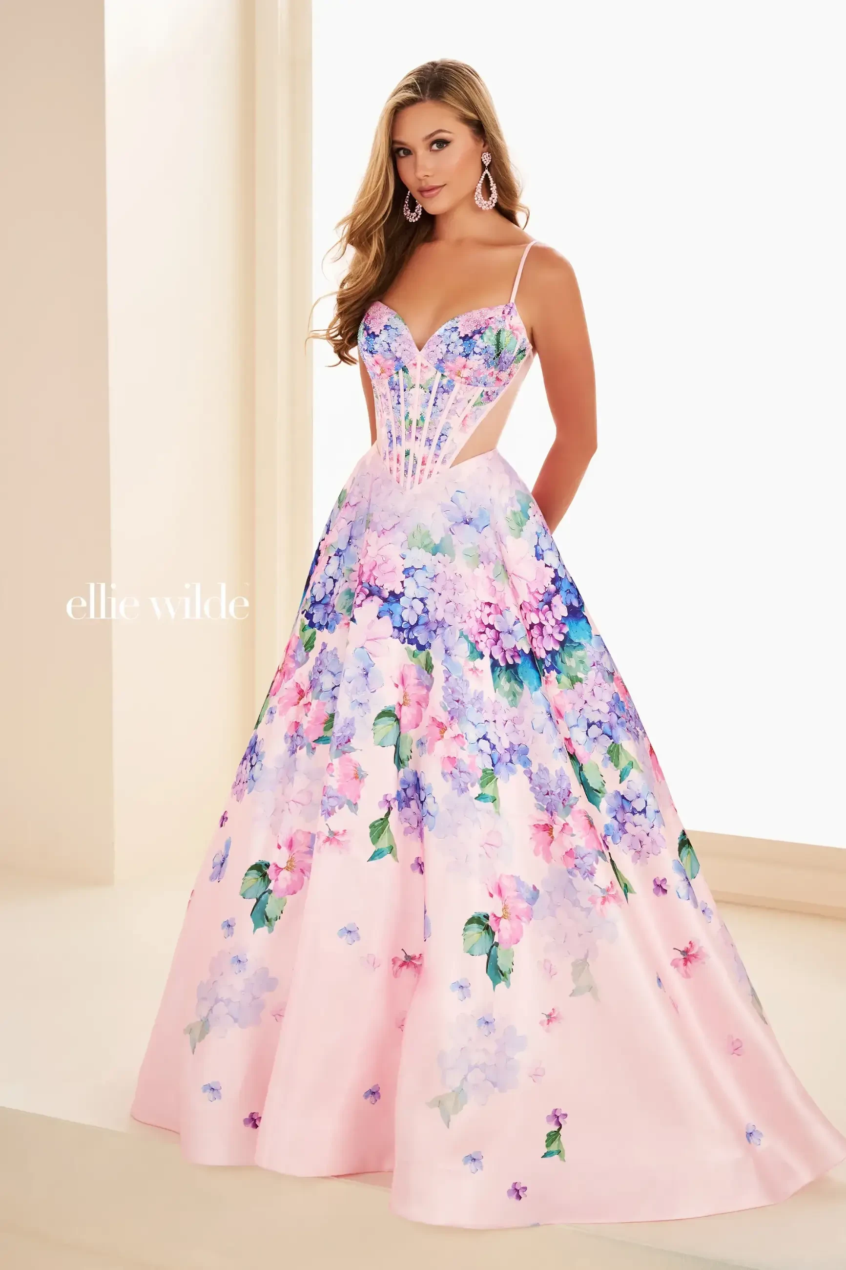 Model is wearing a floral ball gown with a corset bodice