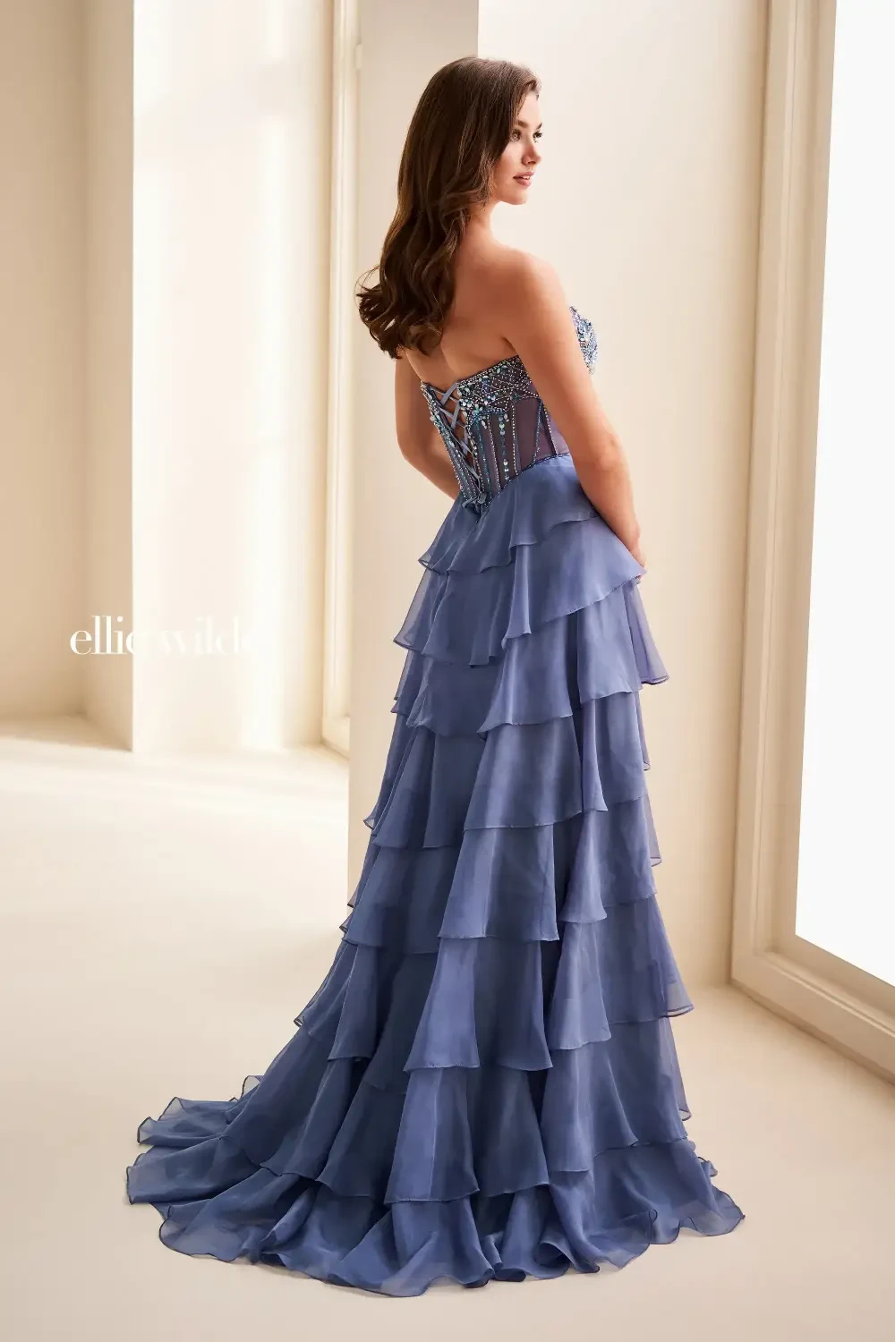 model is wearing a light purple prom dress with a full tiered skirt