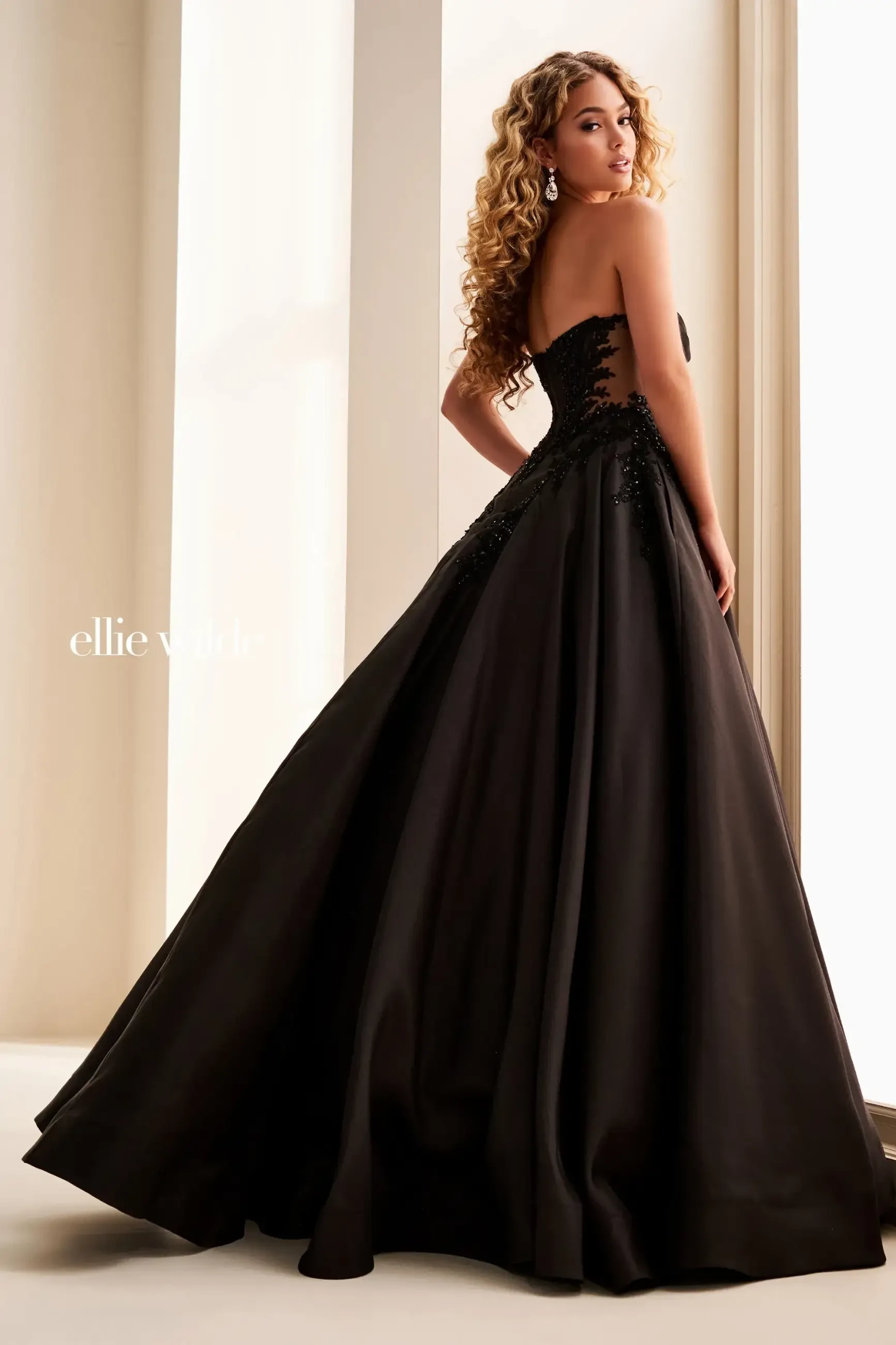 Model is wearing a strapless ball gown with a boned bodice and basque waist