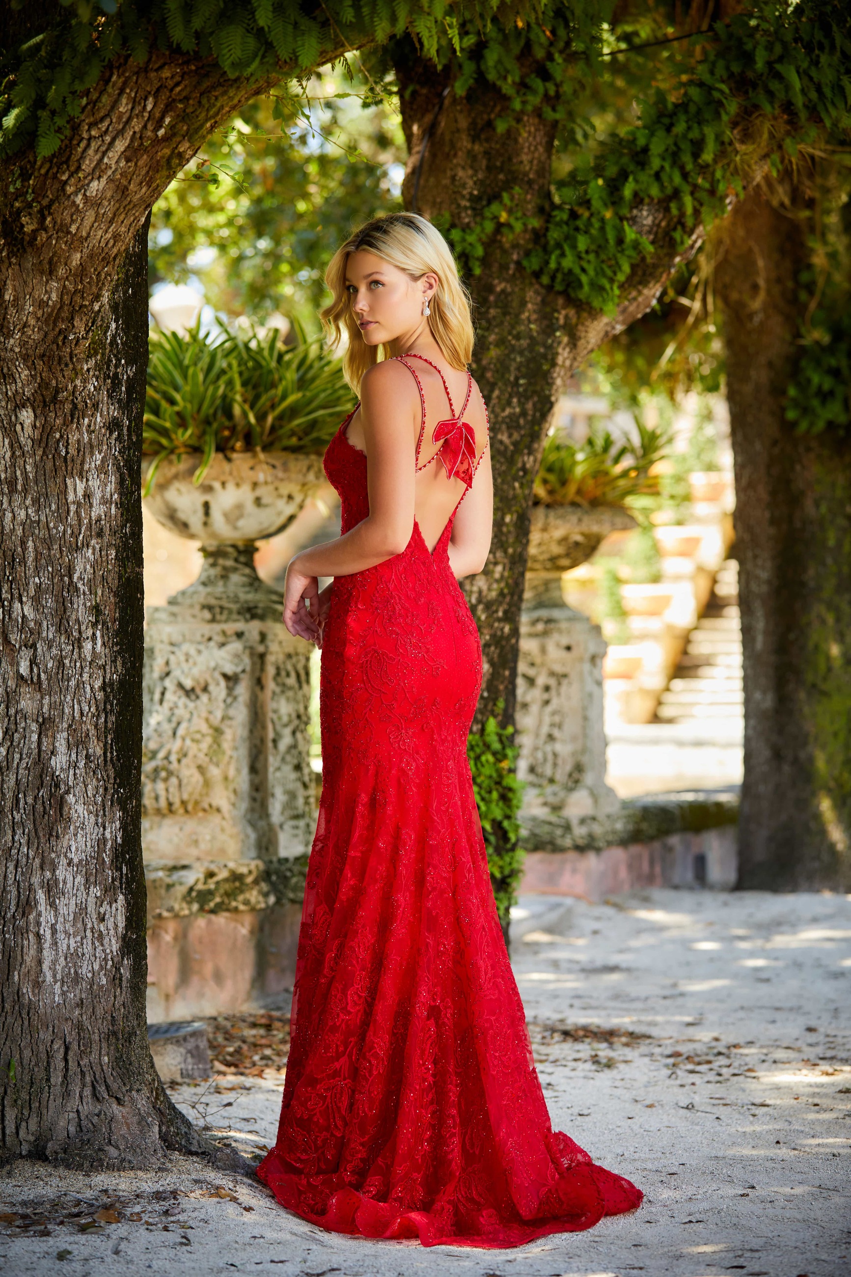 Blonde girl wearing long red dress with open back. Backface