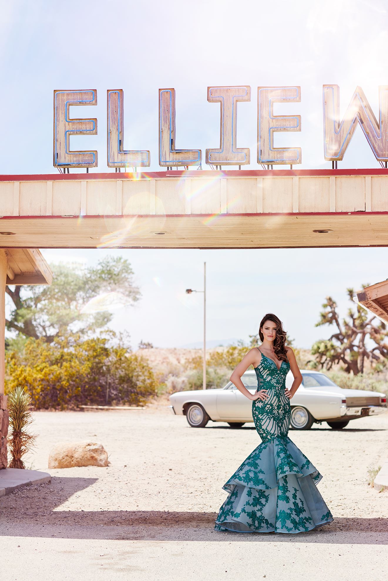 Brunette model in long green prom dress by Ellie Wilde
