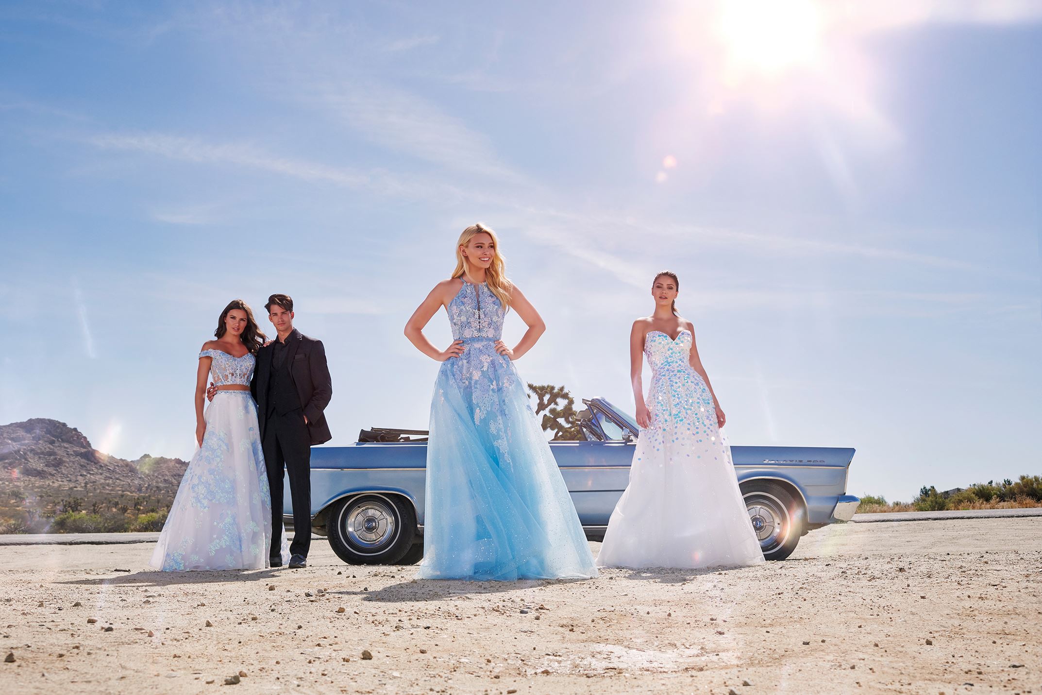 Girls in desert in long prom dresses by Ellie Wilde with a boy Desktop Image